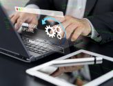 Ingeniero realizando la actualización de software y el mantenimiento técnico continuo de una página web corporativa desde su computadora.