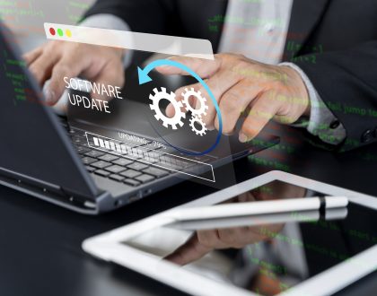 Ingeniero realizando la actualización de software y el mantenimiento técnico continuo de una página web corporativa desde su computadora.